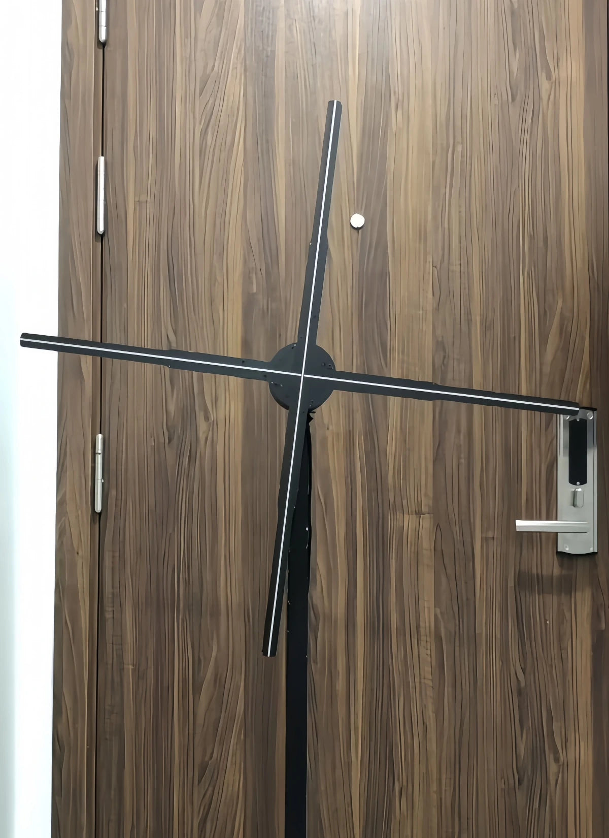 3D holographic fan display mounted in front of a wooden door