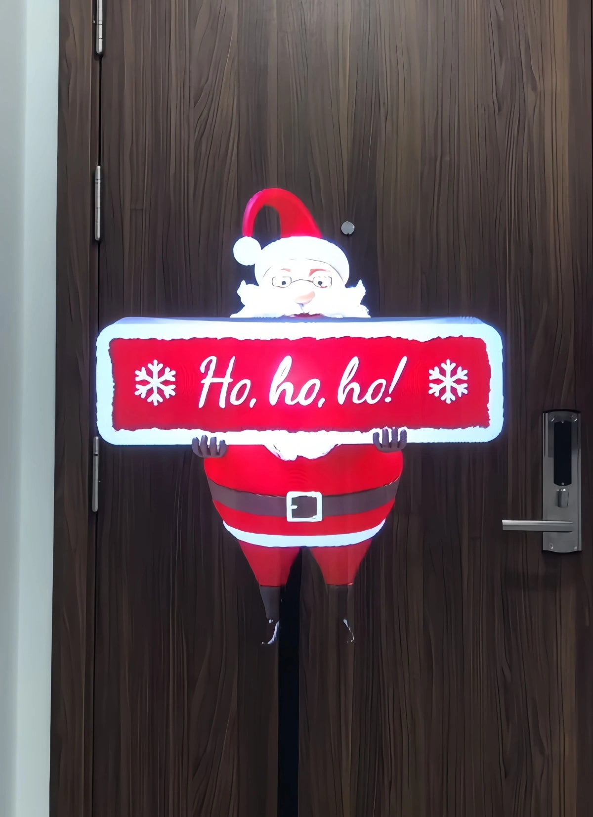 3D holographic display projecting Santa Claus holding a red ‘Ho, ho, ho!’ sign