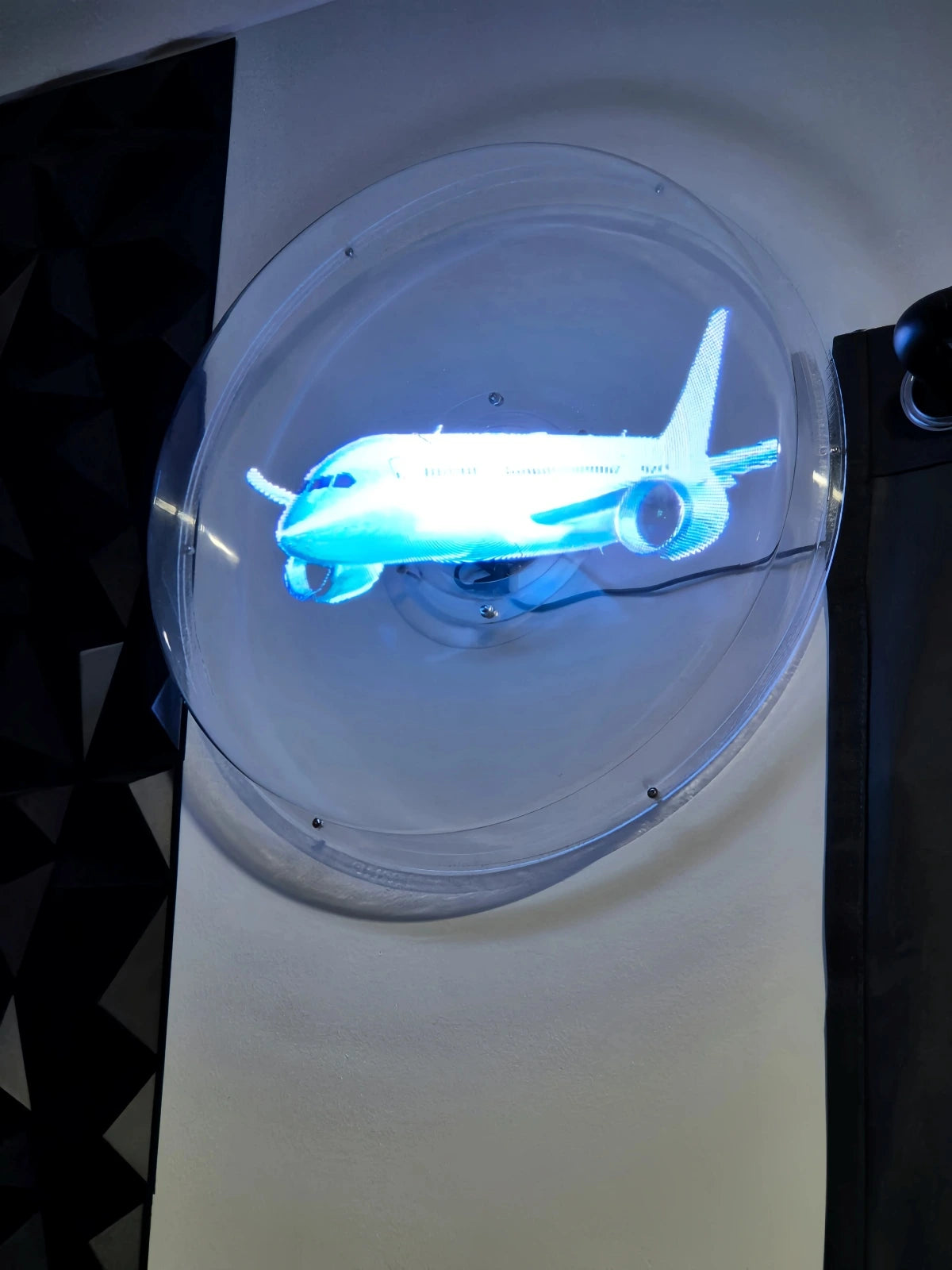 Holographic fan displaying an airplane on a circular cover
