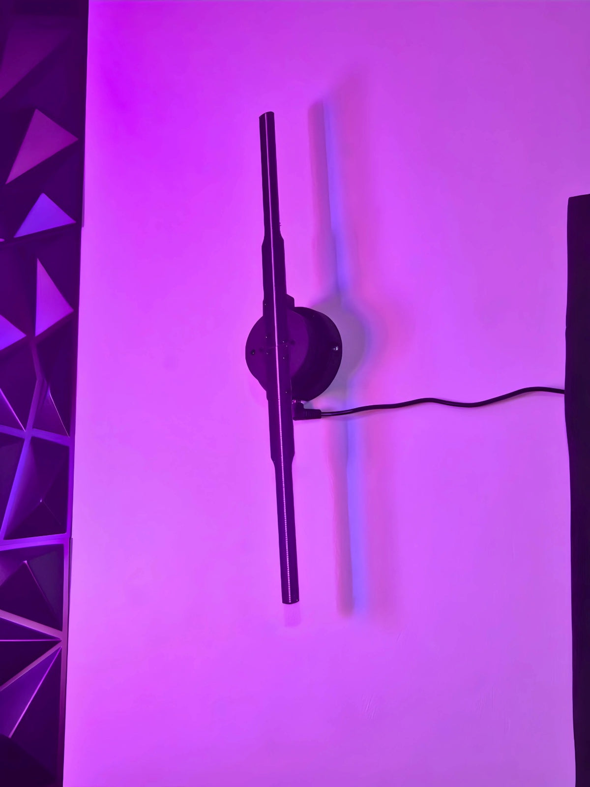 Holographic fan mounted on a wall with purple lighting