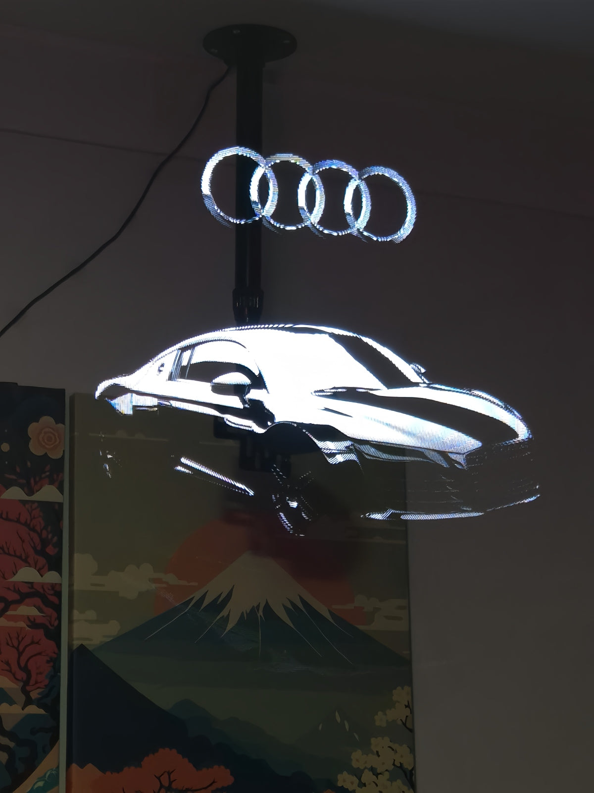 Holographic 3D Audi car projection with the Audi rings logo above it.
