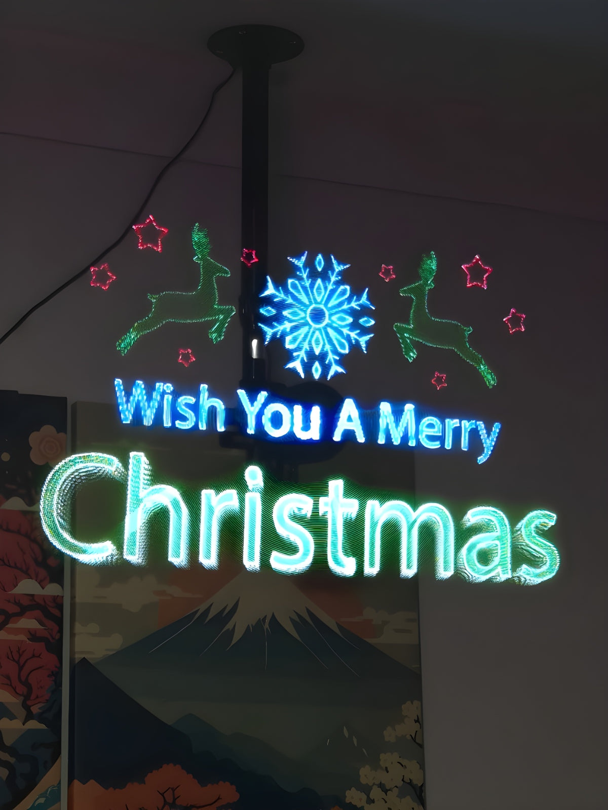 Holographic Christmas display reading Wish You A Merry Christmas with reindeer and stars.
